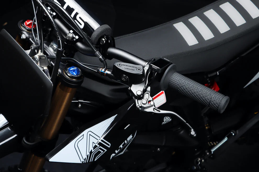 Close-up of a motorcycle handlebar with visible branding on a dark background