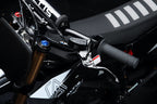Close-up of a motorcycle handlebar with visible branding on a dark background