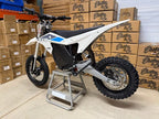 Motocross bike on a stand with boxes in the background