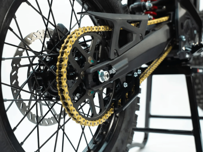 Close-up of a motorcycle chain and sprocket on a white background