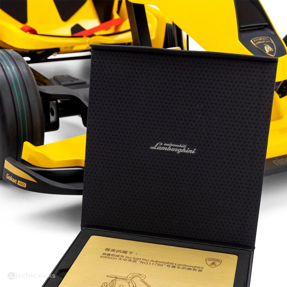 Black textured box with Lamborghini logo in front of a yellow sports car