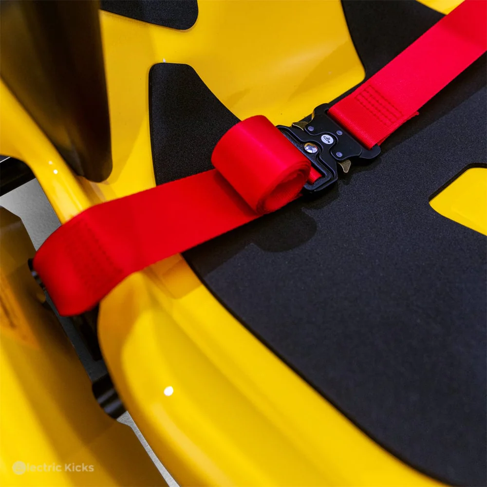 Close-up of a yellow and black scooter with a red seat belt.